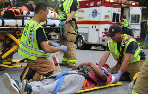 EMS crew provide patient care to patient on stretcher