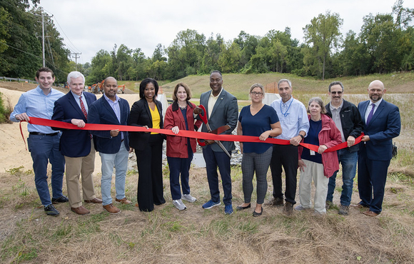 A photo of County Executive Calvin Ball and state and local leaders cutting the ribbon on the completed Ellicott City Safe and Sound Plan's H-4 Pond.