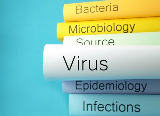 Stack of health books. The word Virus is emphasized on one in the middle