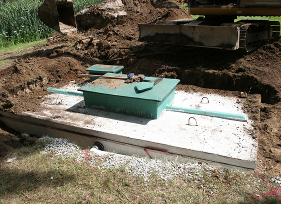 Photo of buried well with construction equipment in the background