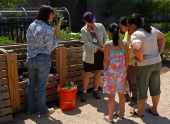 woman instructing people on how to make a compost pile