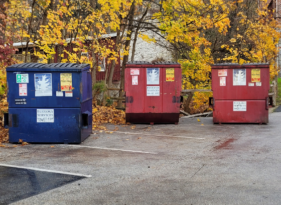 recycling and trash dumpsters in parking lot