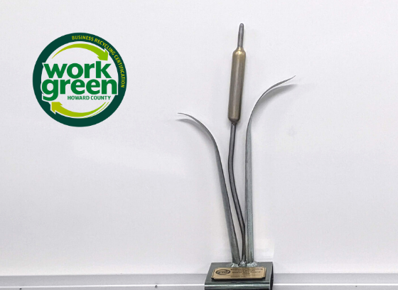 metal trophy next to work green howard logo 