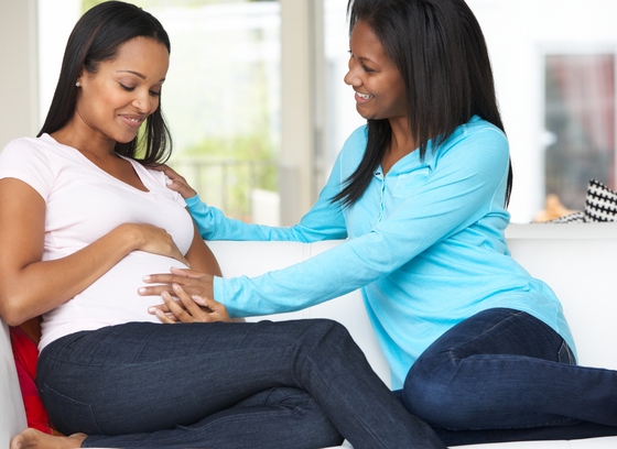 Pregnant African American female with friend giving her support