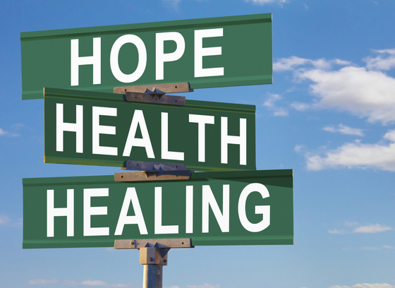 Road sign with three stacked panels, which say "Hope, Health, Healing."