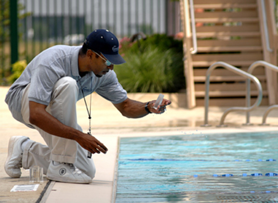 Man checking the pH balance of a pool's water.